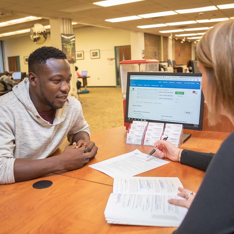 male student at computer desk